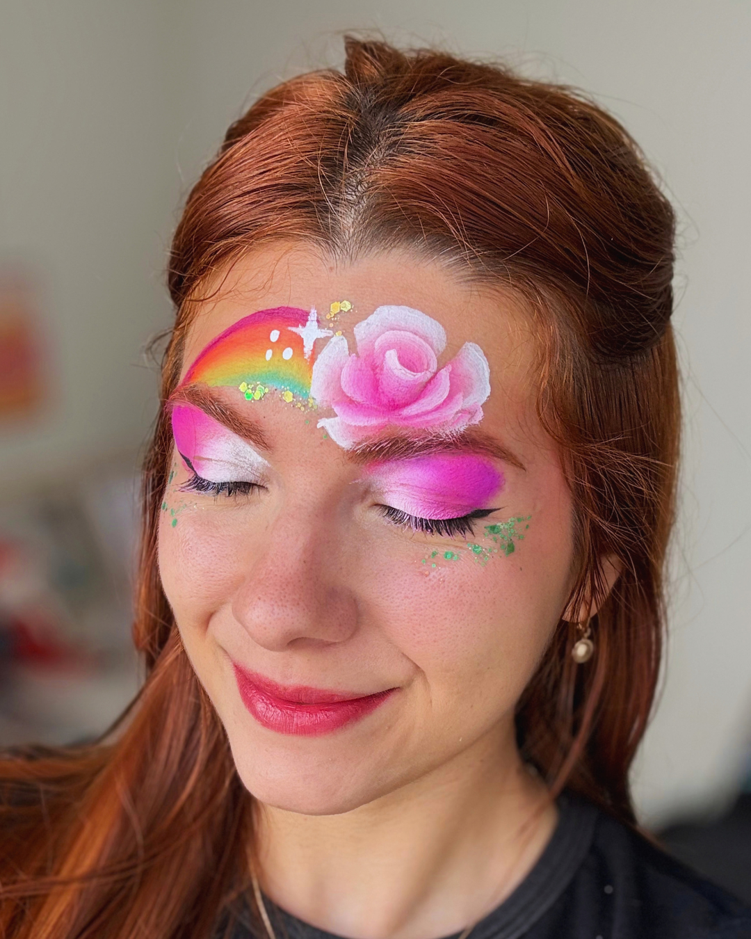 Pintura facial avançada de rosa com arco-íris